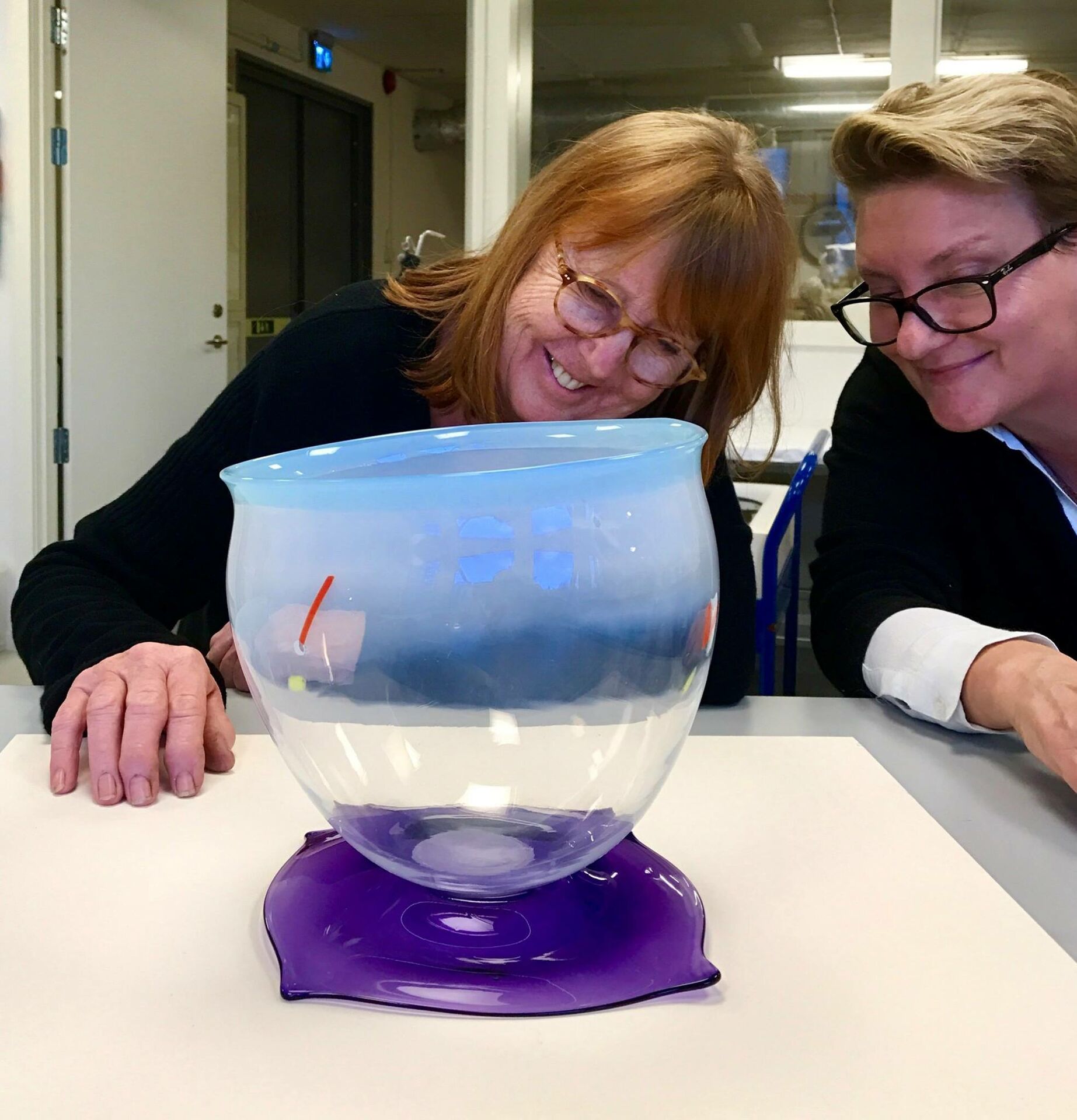 Konservator Charlotta Bylund och konstnär Ulla Forsell diskuterar vilket lim som använts i Forsells verk, skålen Spjutskål