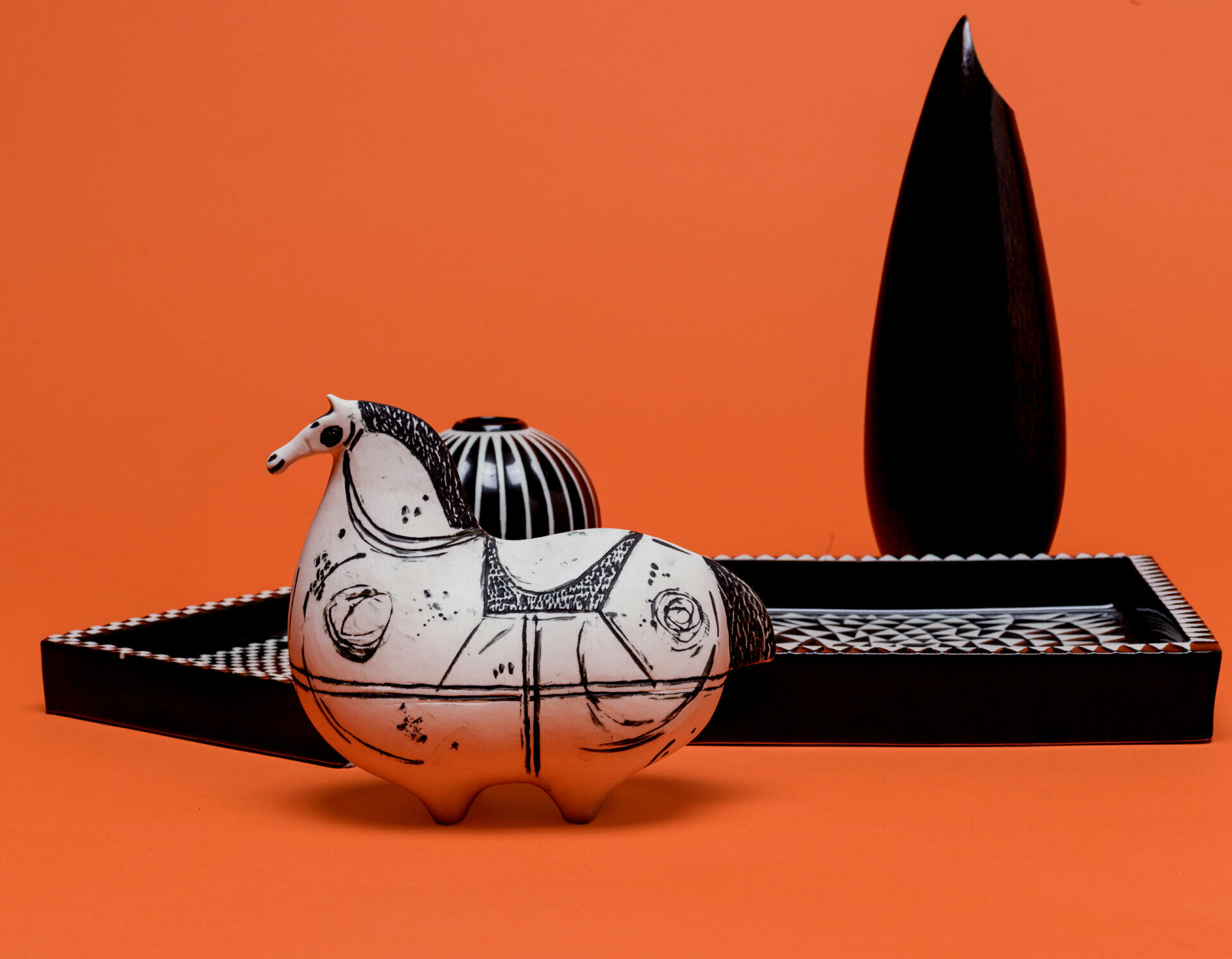 Askfat, vaser och en figurin i form av en häst. Alla i svart och vitt porslin.