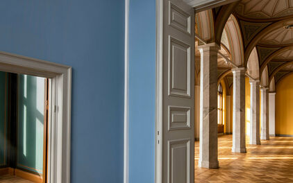 Utblick mot tomma museisalar genom ett par dörröppningar. I den ena salen skymtar dekorativt bemålade valv.