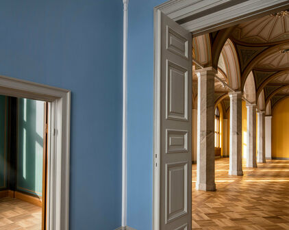 Utblick mot tomma museisalar genom ett par dörröppningar. I den ena salen skymtar dekorativt bemålade valv.