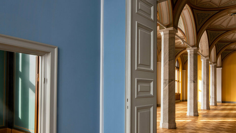 Utblick mot tomma museisalar genom ett par dörröppningar. I den ena salen skymtar dekorativt bemålade valv.