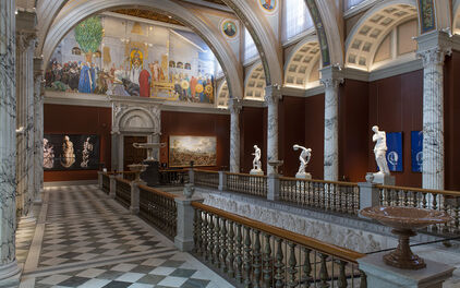 Storslagen trapphall med pelare, väggmålningar och skulpturer.