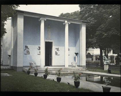 Äldre foto som visar en stram byggnad i nyklassisk stil. I förgrunden en damm och urnor med växter. Sveriges paviljong på Parisutställningen 1925.