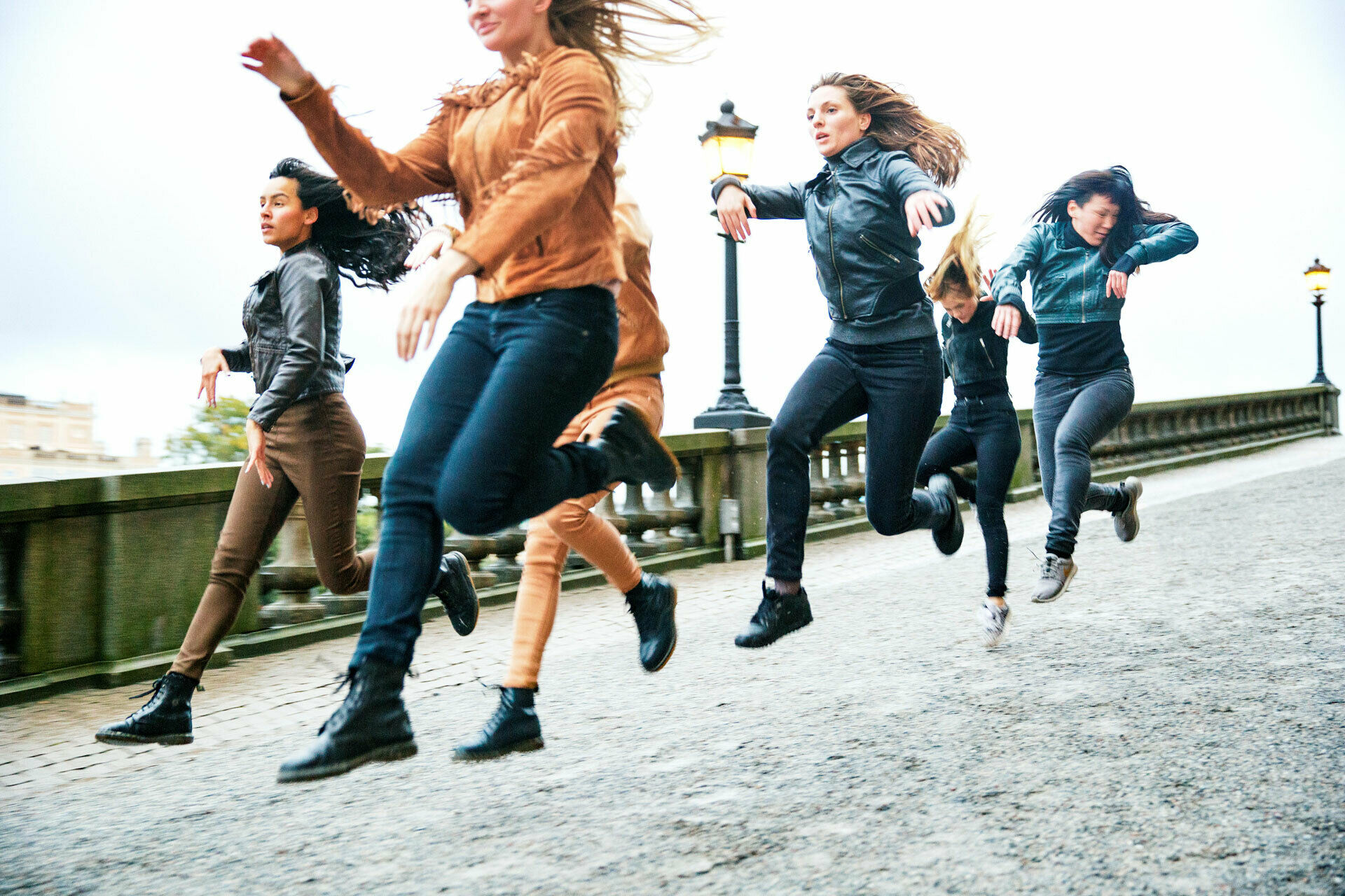 En grupp kvinnor som hoppar fram i full galopp, likt hästar.