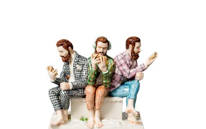 En figurin med tre personer som sitter nära varandra i färgglada kostymer, tittandes ner i sina smartphones.