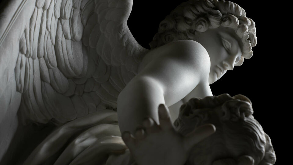 Detalj av marmorskulptur Amor och Psyke. Den bevingade Amor ses snett underifrån.