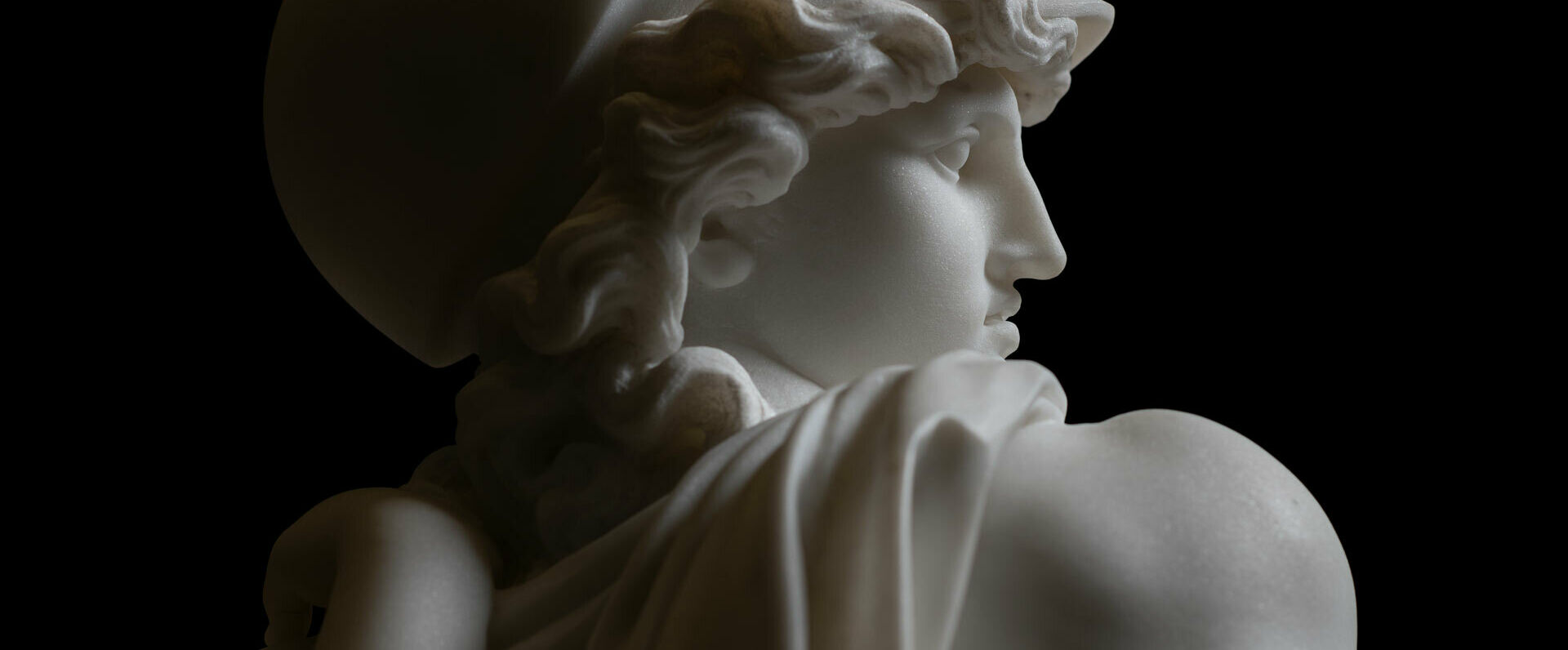 Svartvitt foto av detalj av marmorskulptur föreställande en antik gud.