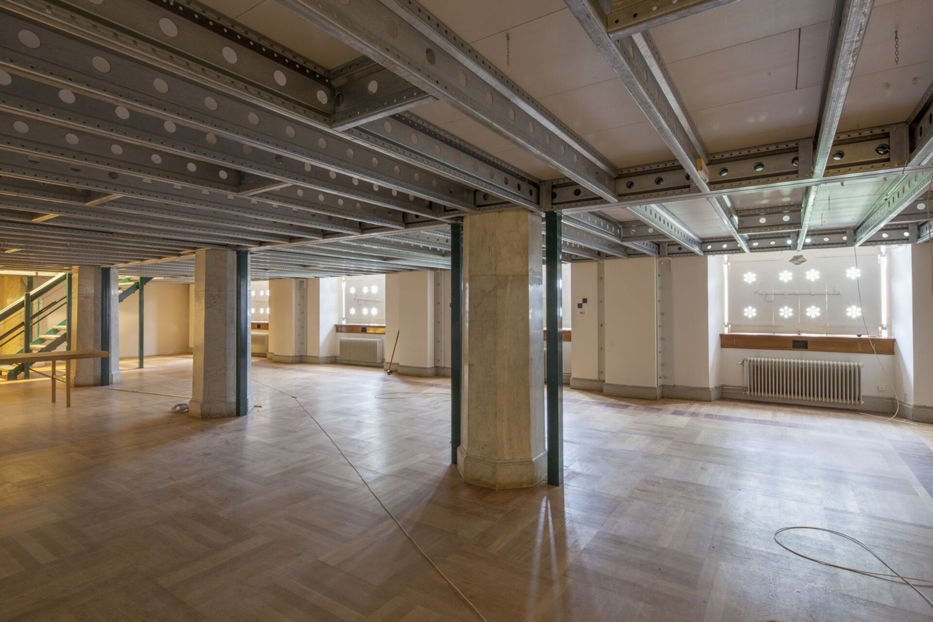 Stort tomt rum med delvis låg takhöjd. Parkettgolv.