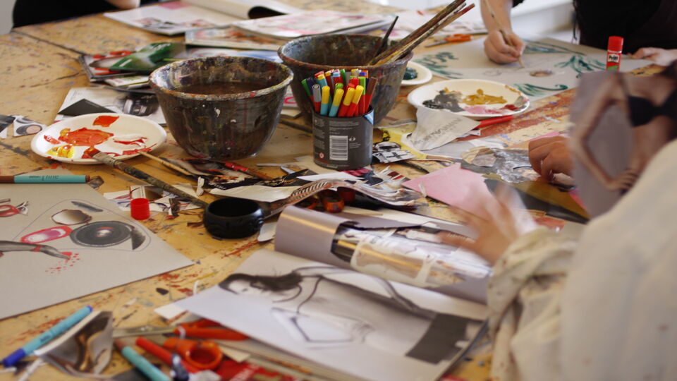 Färg, pennor, tidningsklipp och annat material som blir till collage