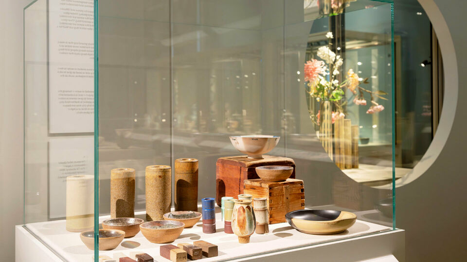 Interiör från utställningen Wilhelm Kåge & Shōji Hamada. Keramikföremål i en monter.