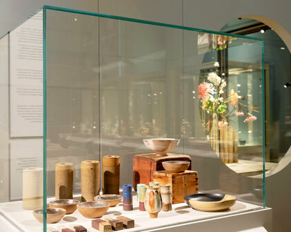 Interiör från utställningen Wilhelm Kåge & Shōji Hamada. Keramikföremål i en monter.