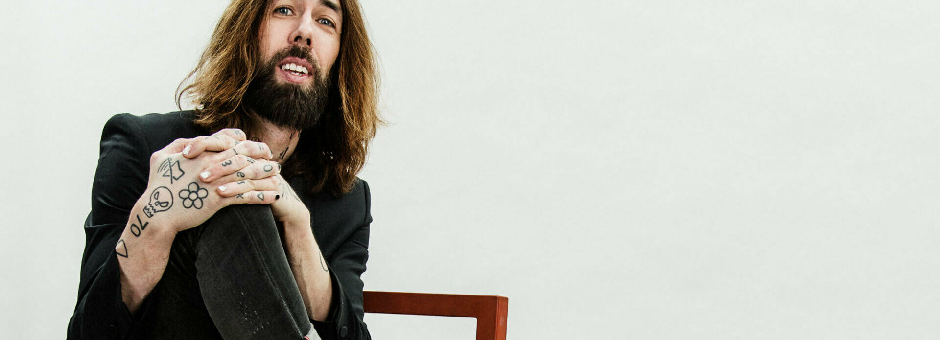 Porträttfoto av en man som sitter på en stol. Fotot föreställer Micael Dahlén.