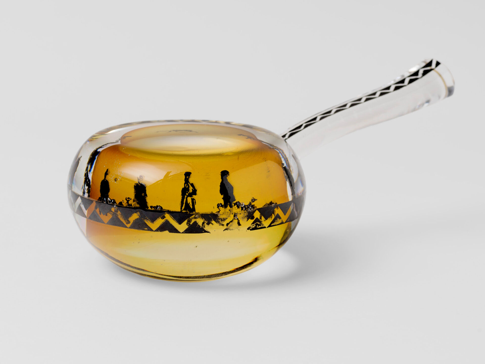 En skålformad glasskulptur inspirerad av en samisk mjölkstäva, med screentryckta fotografiska motiv och emaljerad dekor.