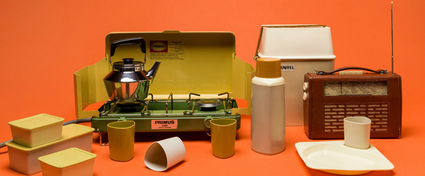 Ett picknick set, en kaffepanna med lock, en transistorradio och ett gasolkök.