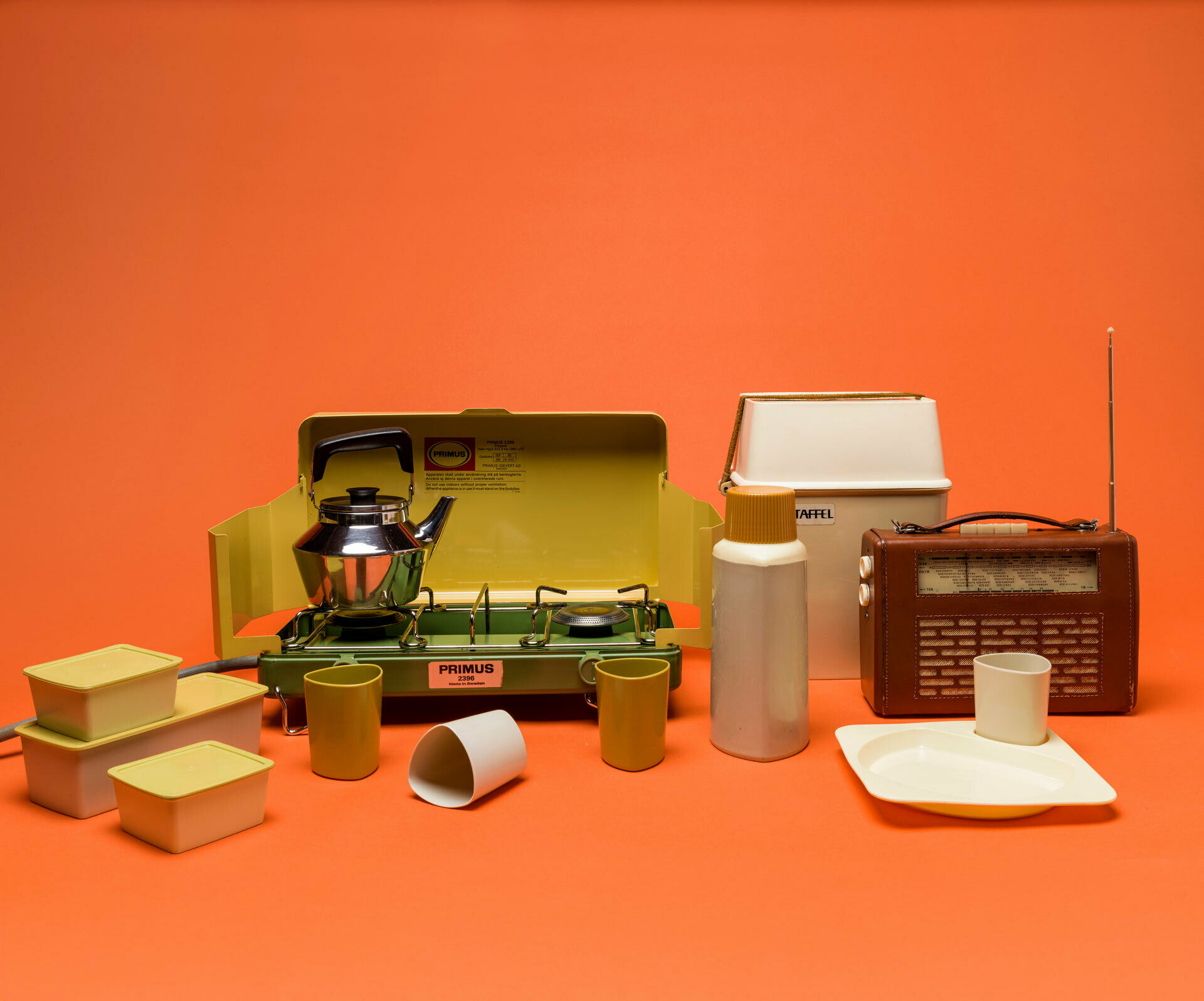 Ett picknick set, en kaffepanna med lock, en transistorradio och ett gasolkök.