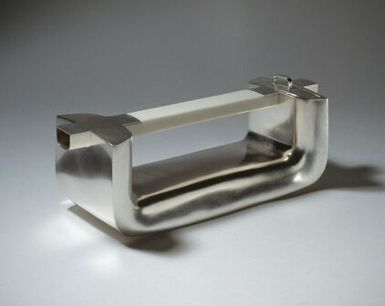 Kanna i silver i form av ett handtag.