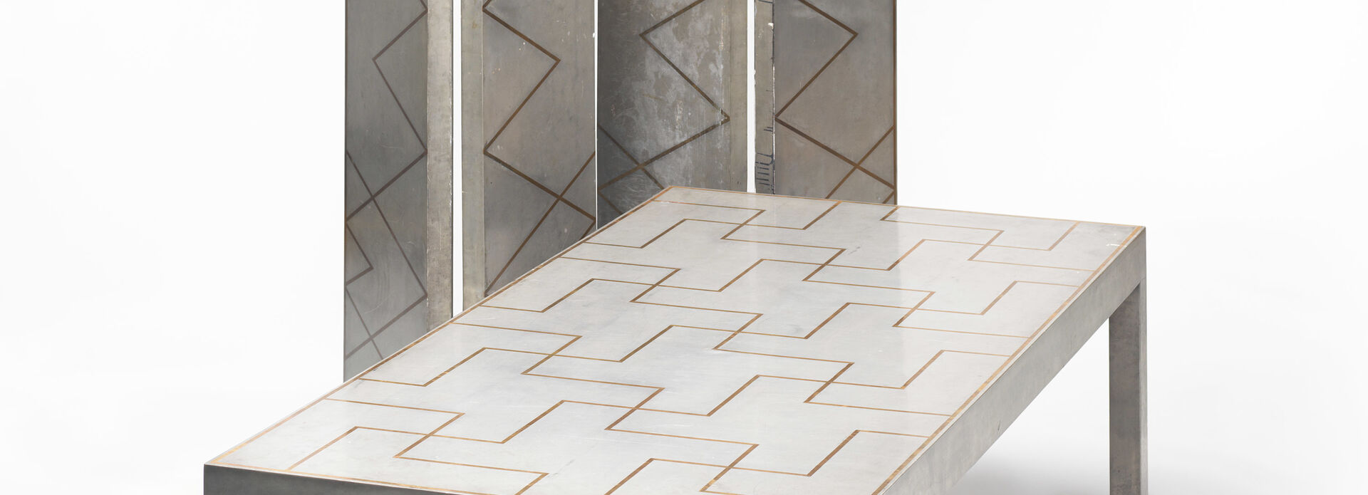 Matsalsmöblemang bestående av bord och en hög skärm av tenn.