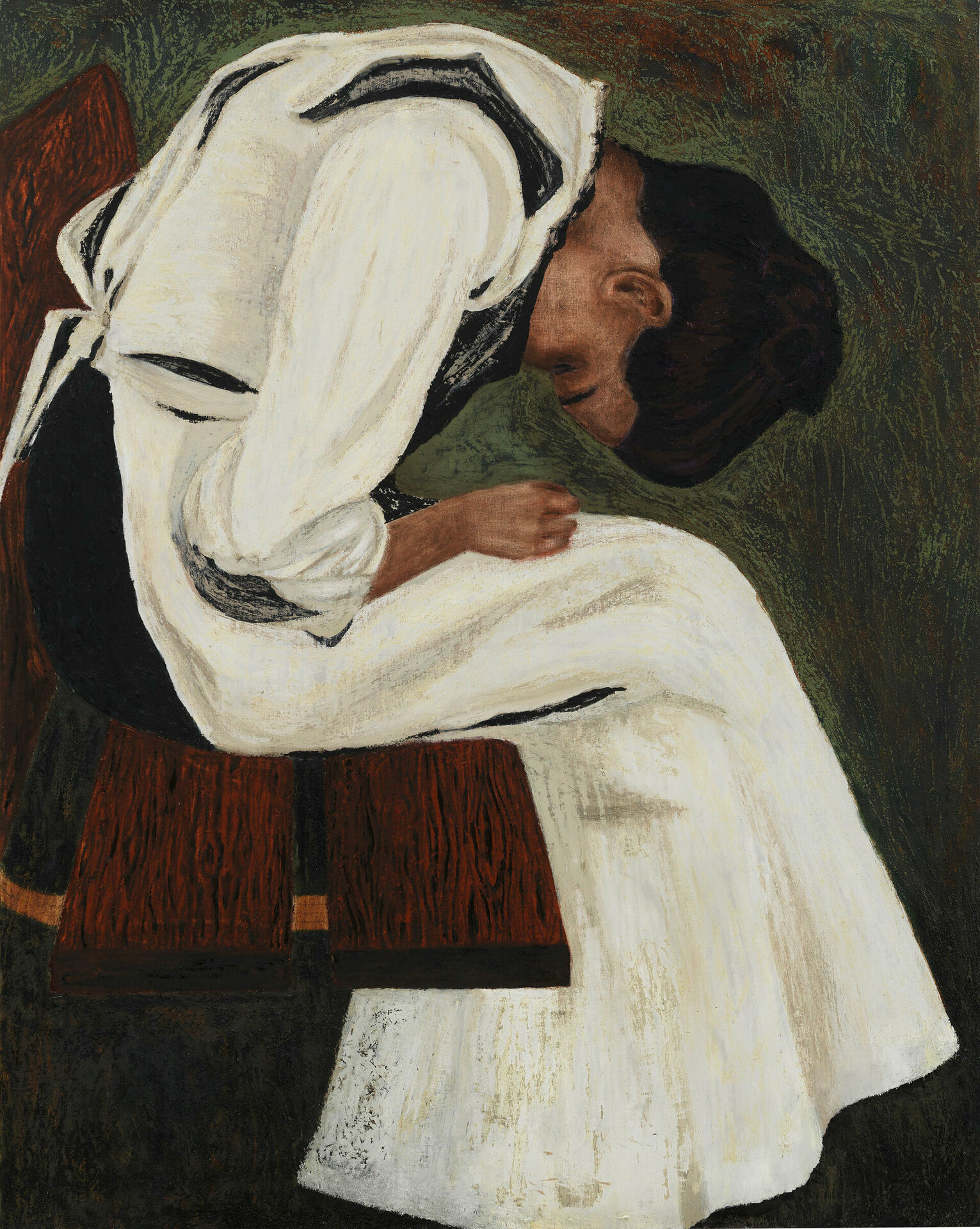 En kvinna i vit klänning som sitter på en stol. Hon kryper ihop och böjer sig framåt med händerna i knät.