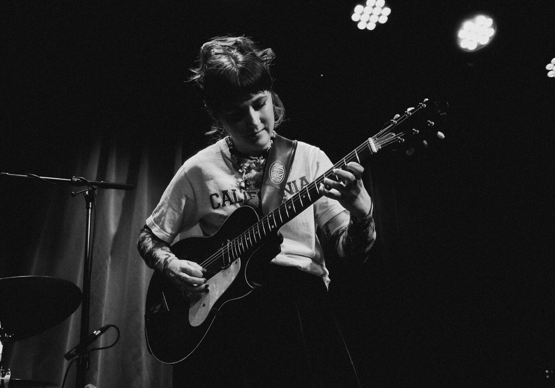 Fotografiskt portärtt av en kvinna som spelar gitarr.