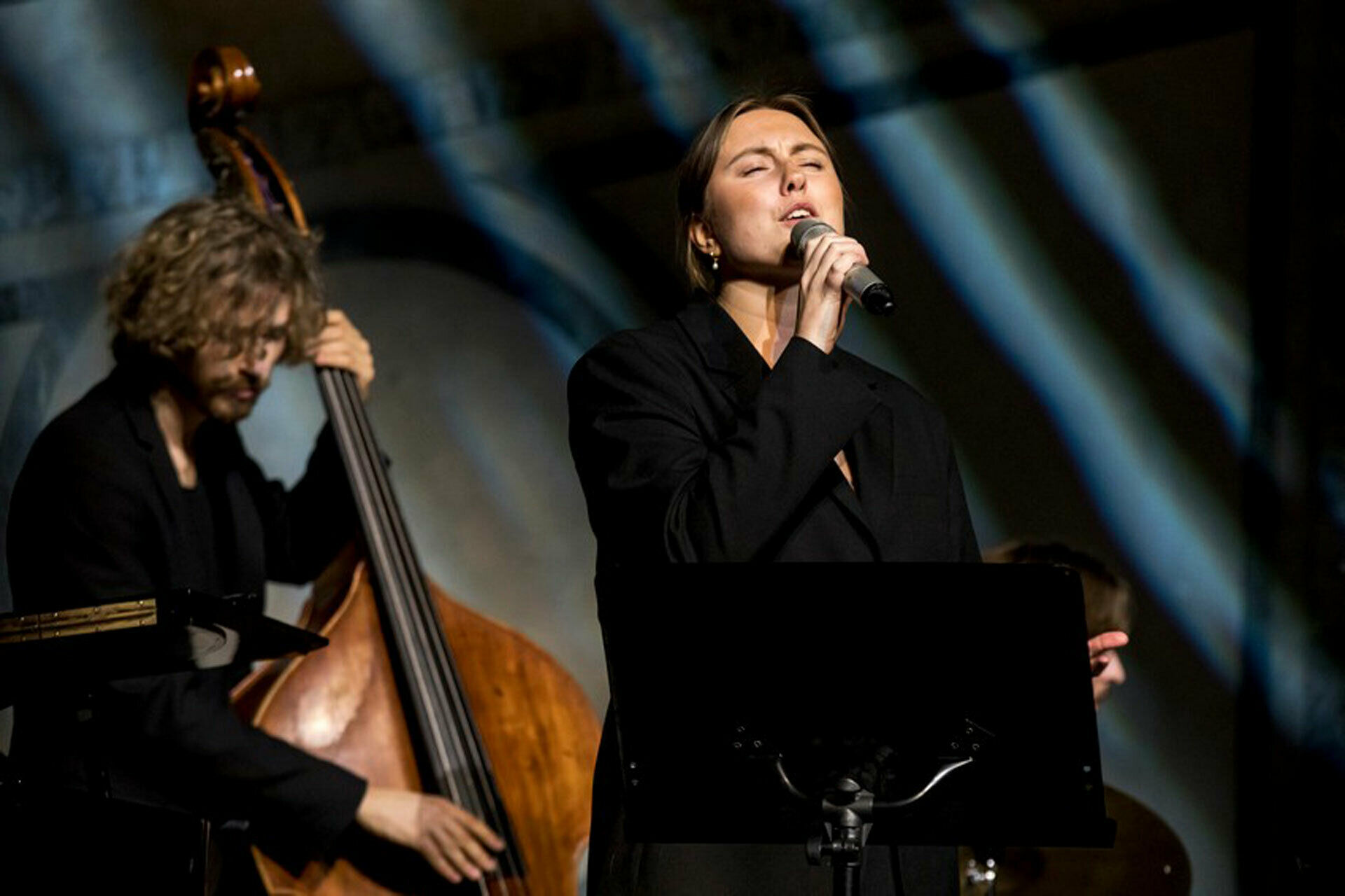 Fotografi av en kvinna som sjunger i mikrofon och en man som spelar kontrabas.