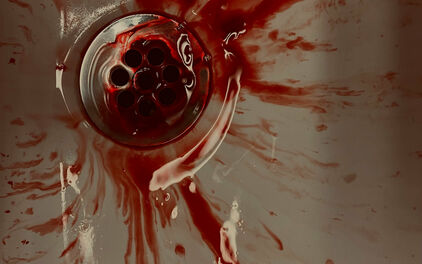 Blod som rinner ner i avloppet i ett handfat.