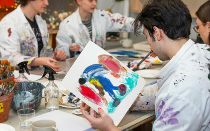 Ungdomar som målar i en ateljé.