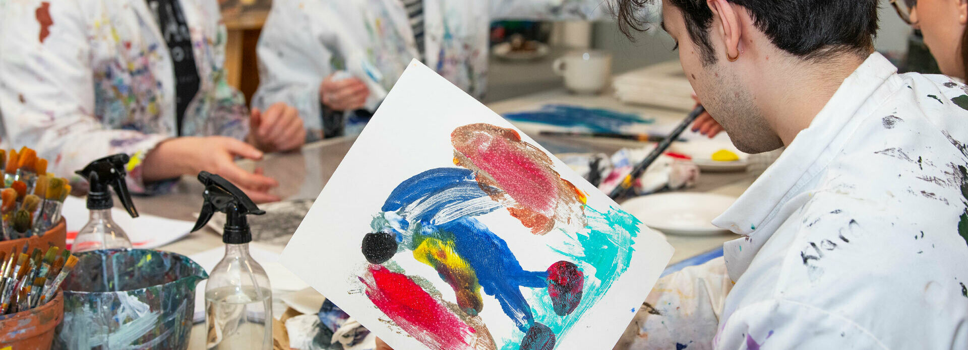 Ungdomar som målar i en ateljé.