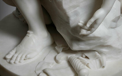 Detalj av skulptur, fot, hand och några verktyg som används vid skulptering.