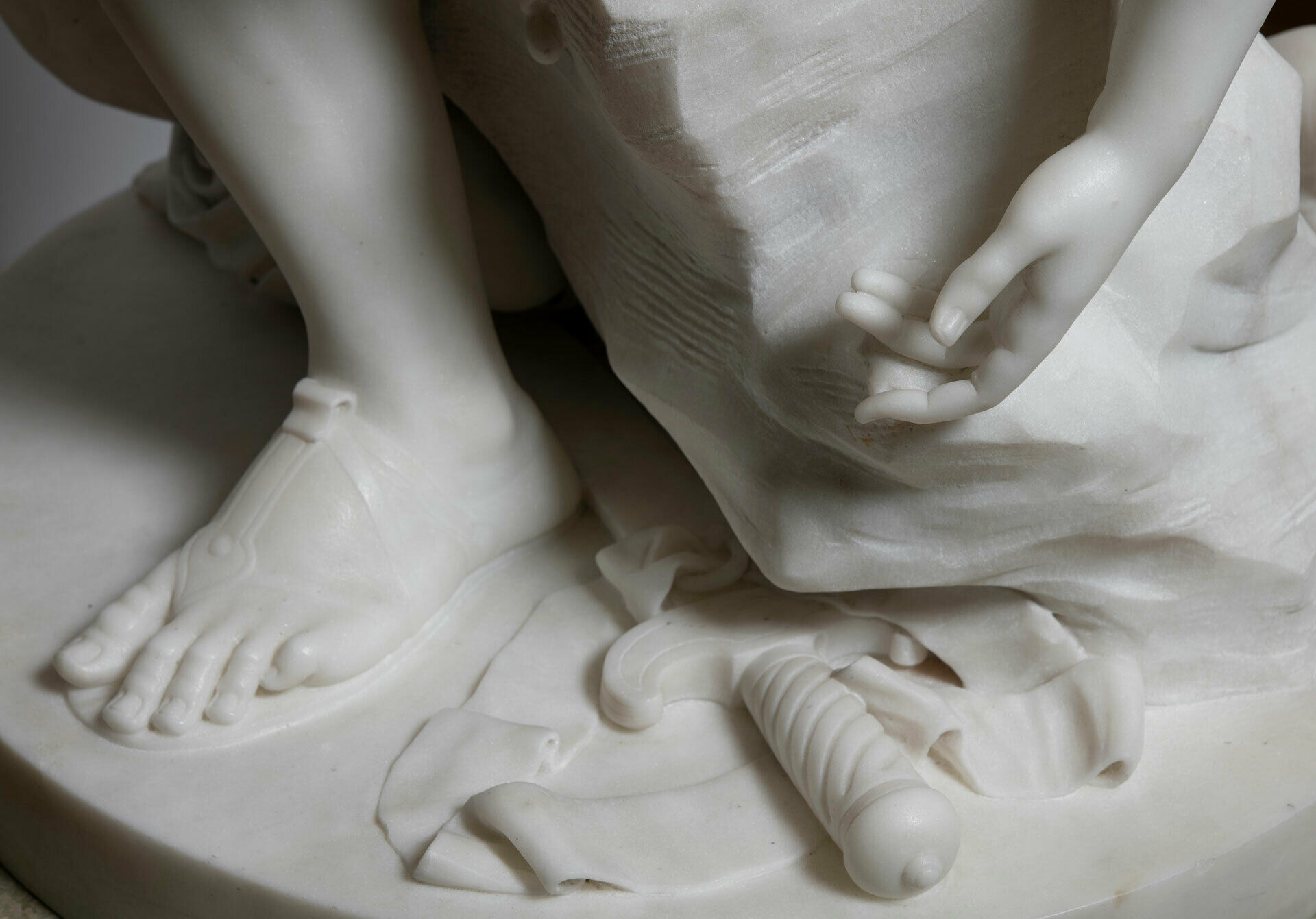 Detalj av skulptur, fot, hand och några verktyg som används vid skulptering.