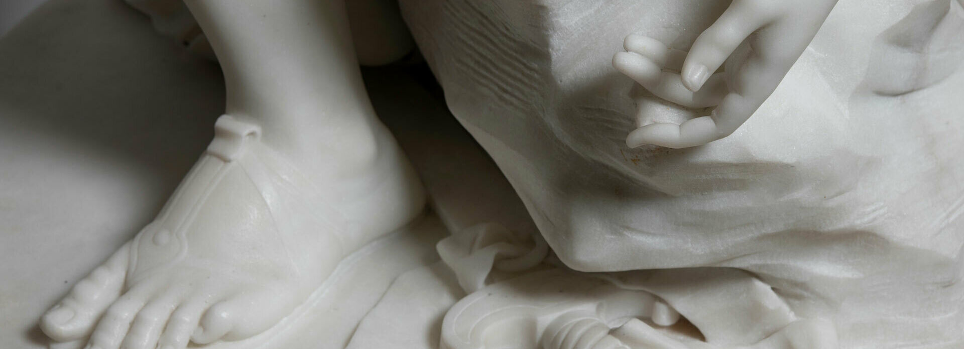 Detalj av skulptur, fot, hand och några verktyg som används vid skulptering.