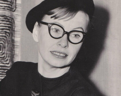 Svartvitt porträttfotografi av en kvinna i mörk klänning och basker.