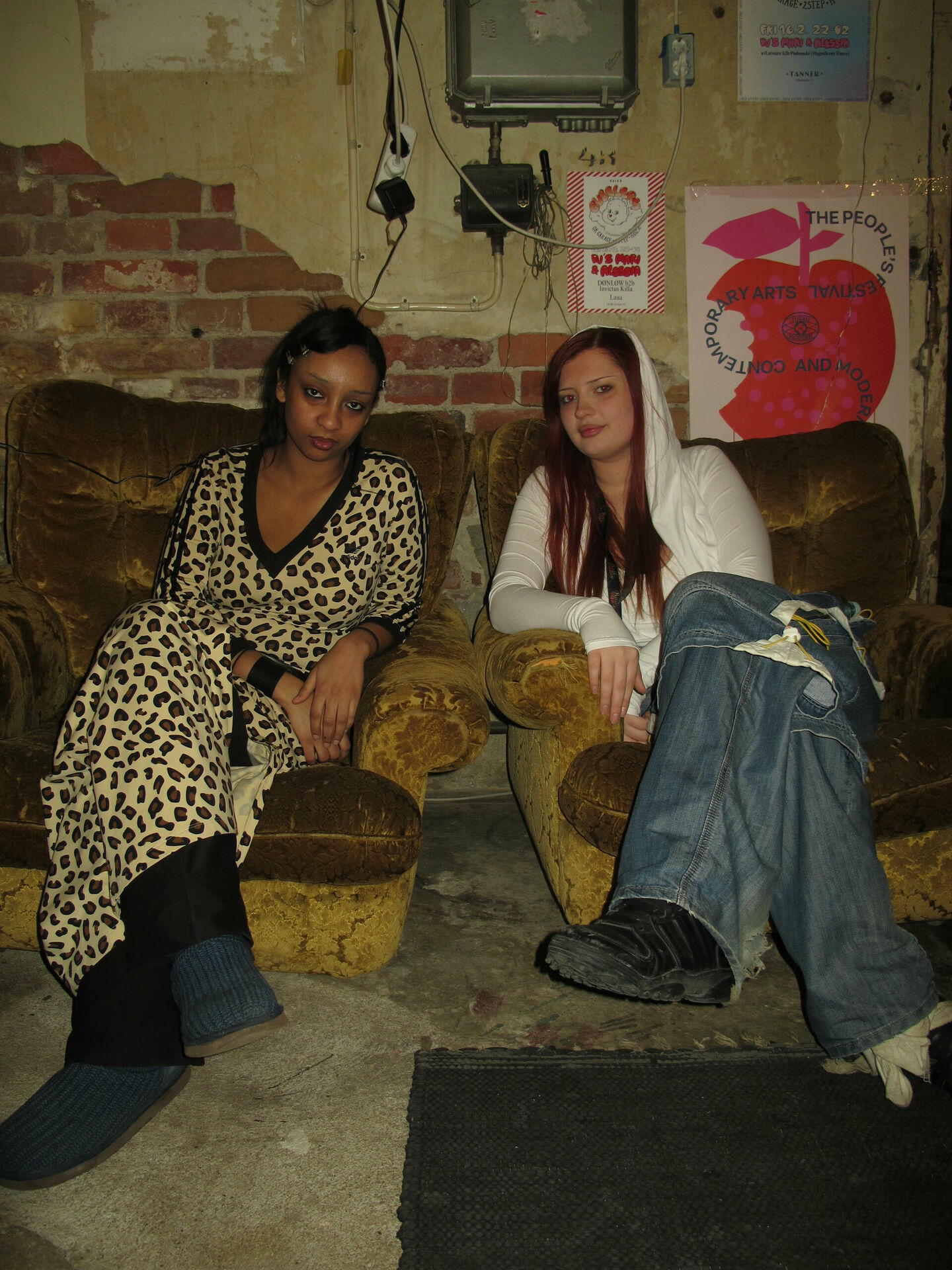 Två unga kvinnor som sitter i varsin fåtölj i ett rum som ser ut som en replokal eller liknande.