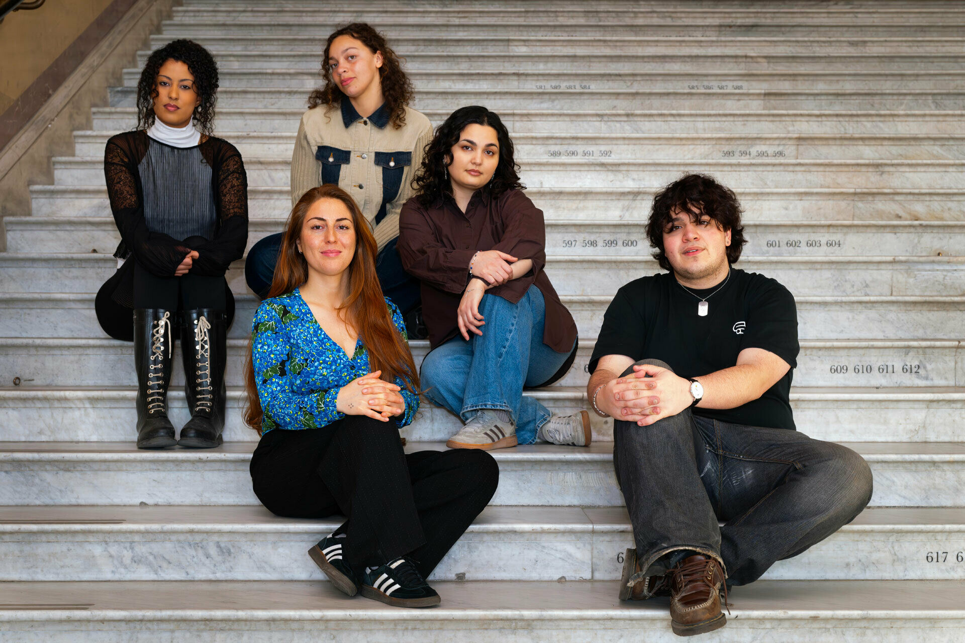 Några personer som sitter i en stor stentrappa.