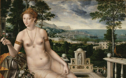 En naken gudinna, Venus, sitter med utsträckta ben på en terrass framför ett idylliskt kustlandskap.