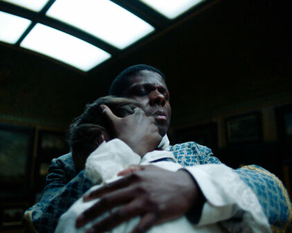 Foto från film, med en man i 1700-talskläder som står och håller om en annan man.