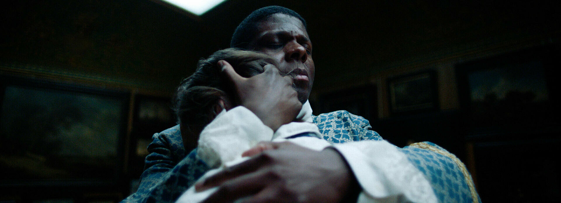 Foto från film, med en man i 1700-talskläder som står och håller om en annan man.